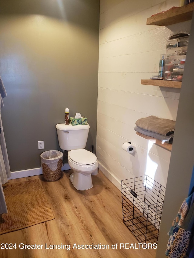 bathroom with toilet and hardwood / wood-style flooring