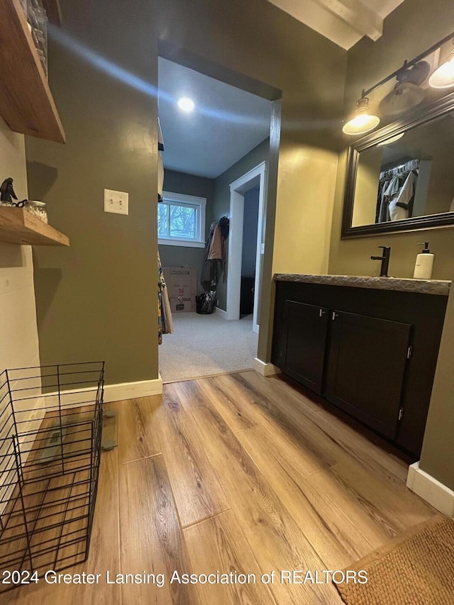 hallway with light hardwood / wood-style flooring and sink