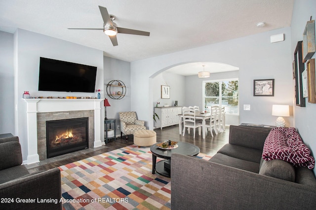 living room with ceiling fan, dark wood-type flooring, and a textured ceiling