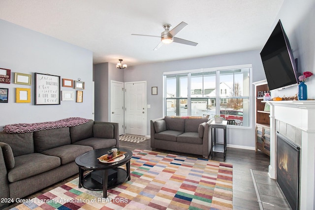 living room with ceiling fan, wood-type flooring, and a tiled fireplace