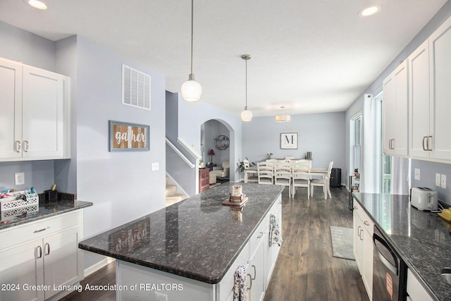 kitchen featuring dark wood-type flooring, stainless steel dishwasher, dark stone countertops, decorative light fixtures, and white cabinetry