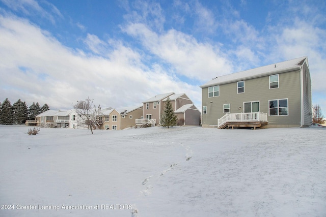 snow covered house featuring a wooden deck