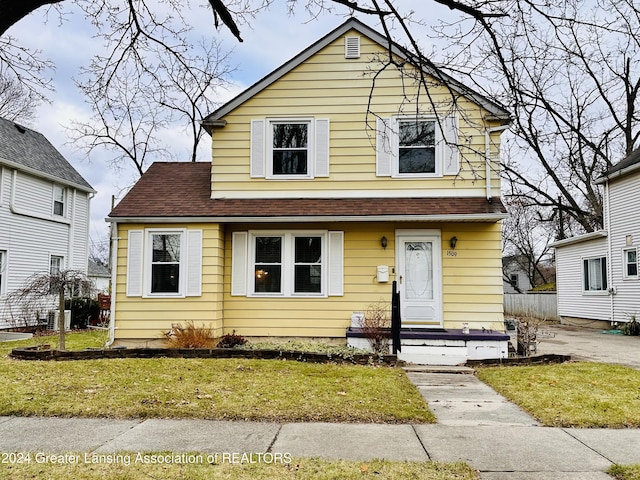 view of front of house with central AC and a front yard