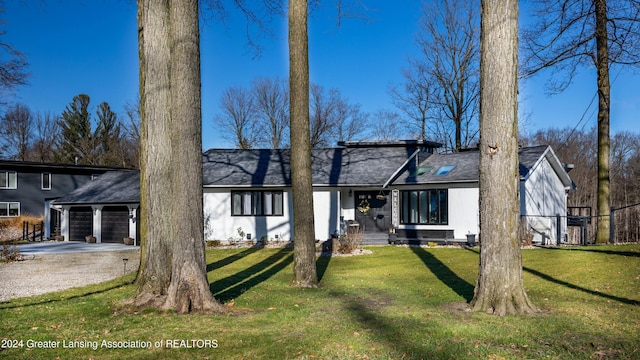 back of property featuring a yard and a garage