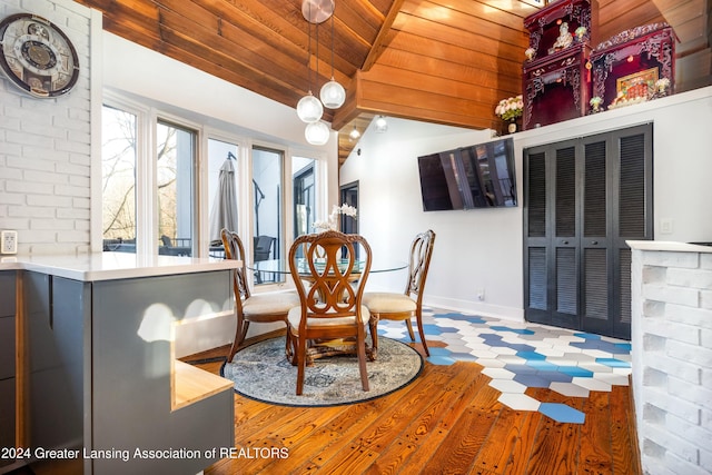 dining area featuring hardwood / wood-style floors, vaulted ceiling with beams, and wood ceiling