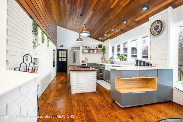 kitchen with pendant lighting, backsplash, dark hardwood / wood-style flooring, wood ceiling, and brick wall