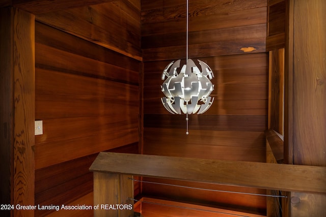 unfurnished dining area featuring wood walls