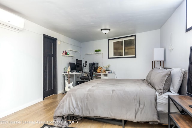 bedroom featuring a wall mounted air conditioner and light wood-type flooring