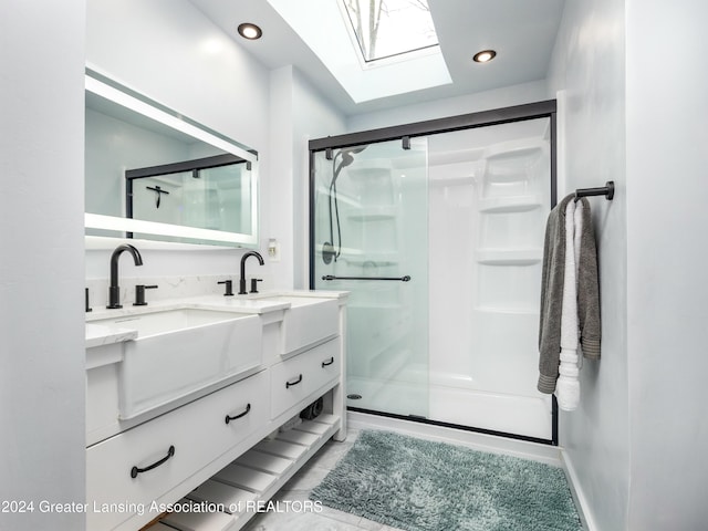 bathroom featuring vanity, a shower with shower door, and a skylight