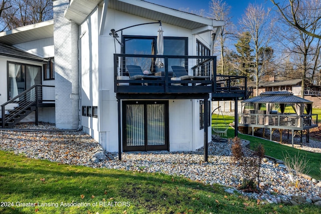 rear view of property with a gazebo, a lawn, and a wooden deck