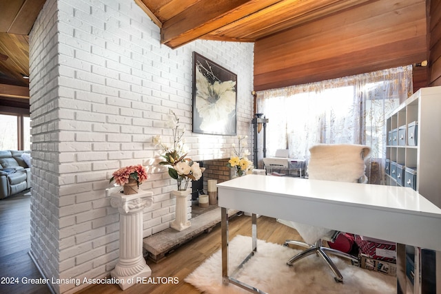 office featuring hardwood / wood-style flooring, lofted ceiling with beams, wood ceiling, and brick wall