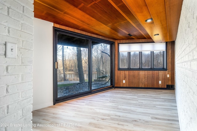 interior space with wooden walls, wooden ceiling, and light wood-type flooring