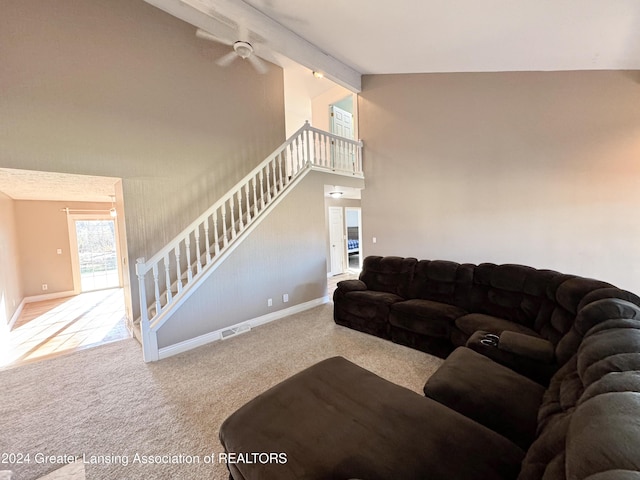 living room featuring beam ceiling, light colored carpet, and high vaulted ceiling