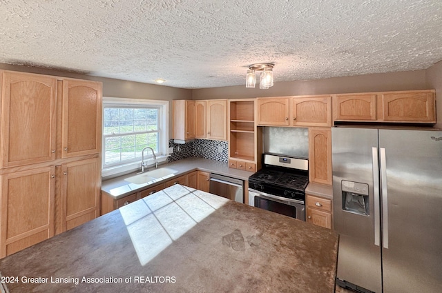 kitchen featuring backsplash, a textured ceiling, stainless steel appliances, sink, and light brown cabinets