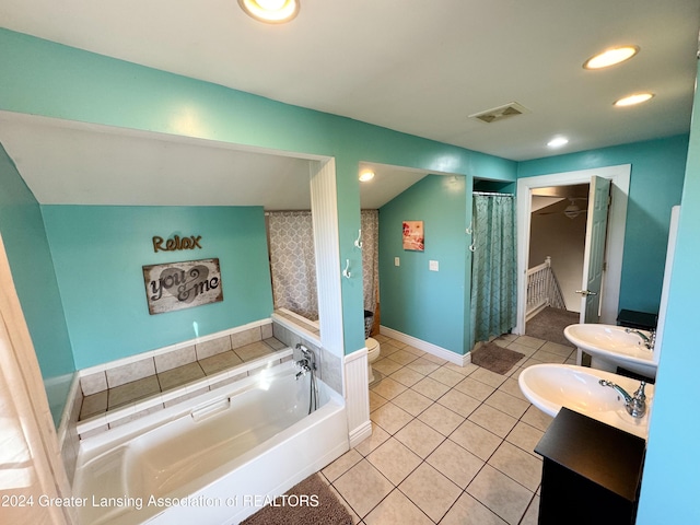 bathroom with sink, a tub to relax in, tile patterned floors, lofted ceiling, and toilet