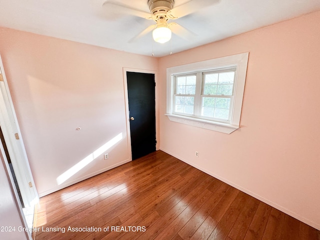 empty room with hardwood / wood-style flooring and ceiling fan