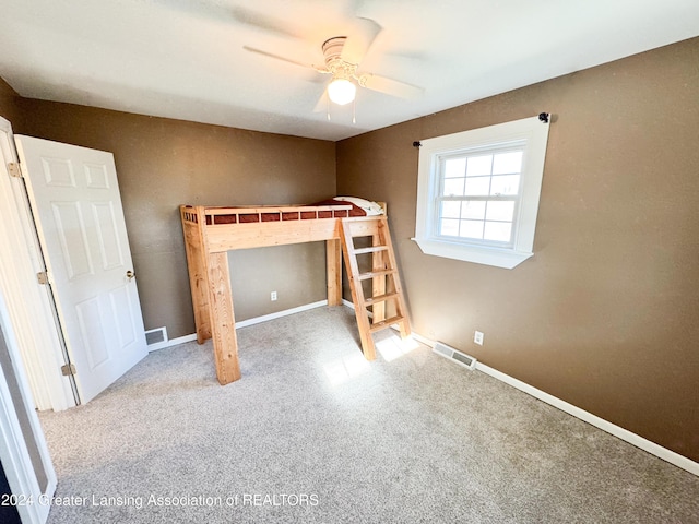 unfurnished bedroom with ceiling fan and light colored carpet