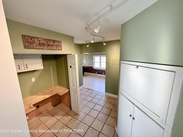 kitchen with white cabinets, light tile patterned flooring, and track lighting