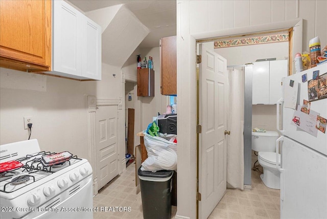 kitchen with white gas range and white cabinets