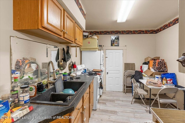 kitchen featuring white fridge, light wood-type flooring, sink, and stainless steel stove