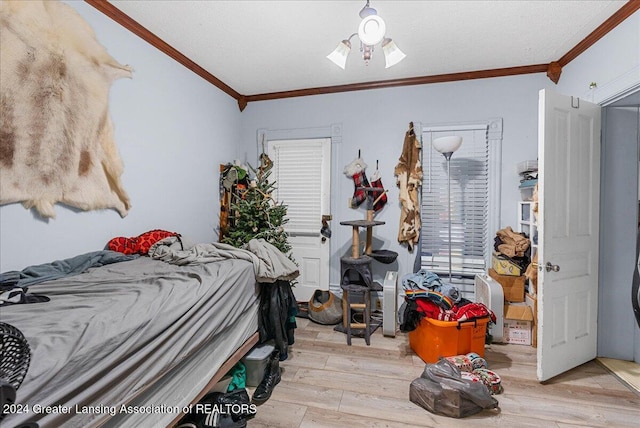 bedroom featuring crown molding and light hardwood / wood-style flooring