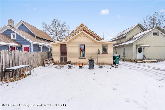 view of snow covered back of property