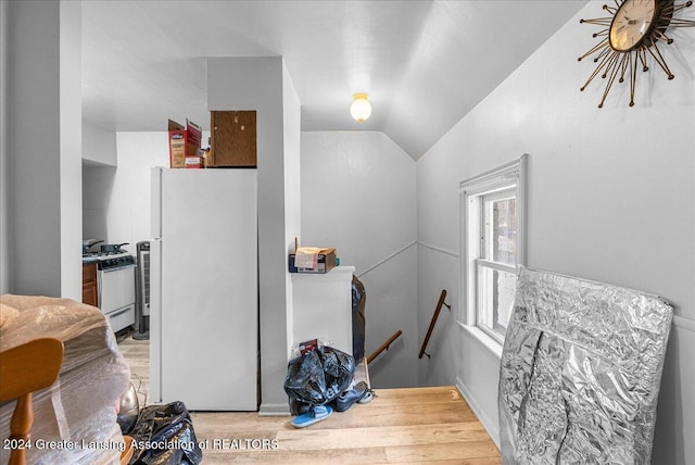 stairs with hardwood / wood-style floors and vaulted ceiling