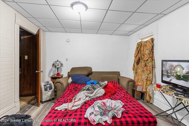 bedroom featuring a paneled ceiling and light wood-type flooring