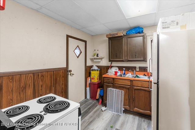 kitchen featuring stainless steel refrigerator, sink, white electric range oven, light hardwood / wood-style floors, and a paneled ceiling