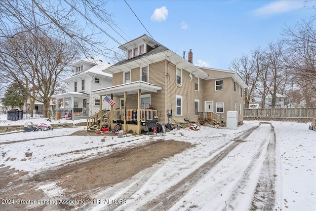 view of snow covered back of property