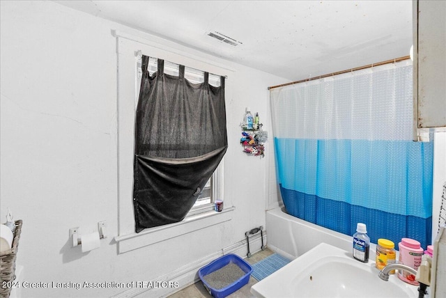 bathroom with sink and shower / tub combo with curtain