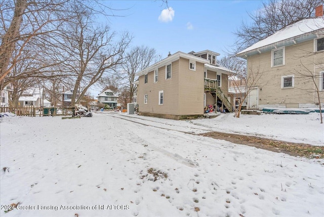 snow covered property featuring central AC