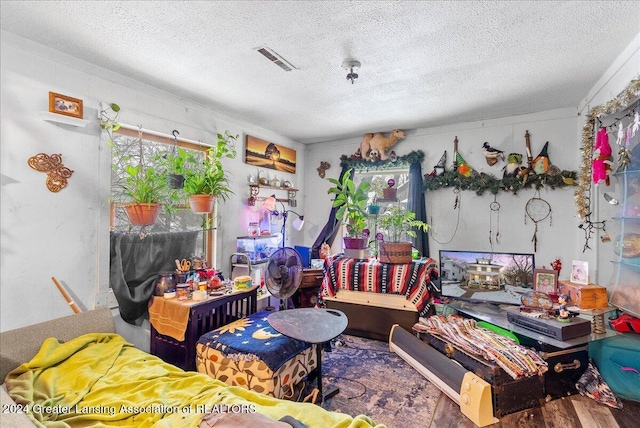 game room with hardwood / wood-style floors and a textured ceiling