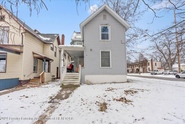 view of snow covered rear of property