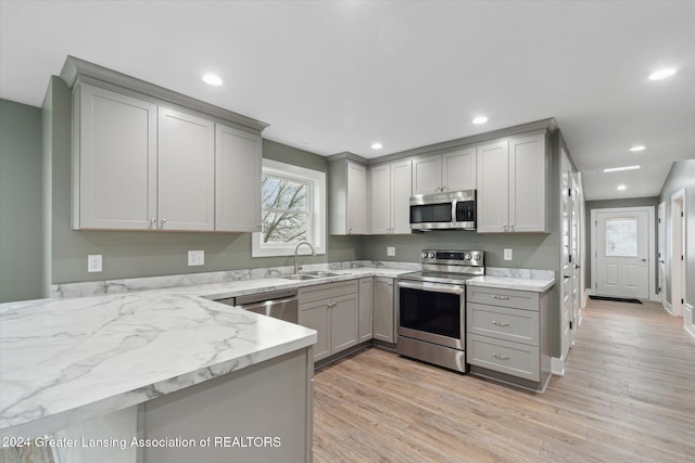 kitchen featuring gray cabinets, sink, stainless steel appliances, and light hardwood / wood-style flooring