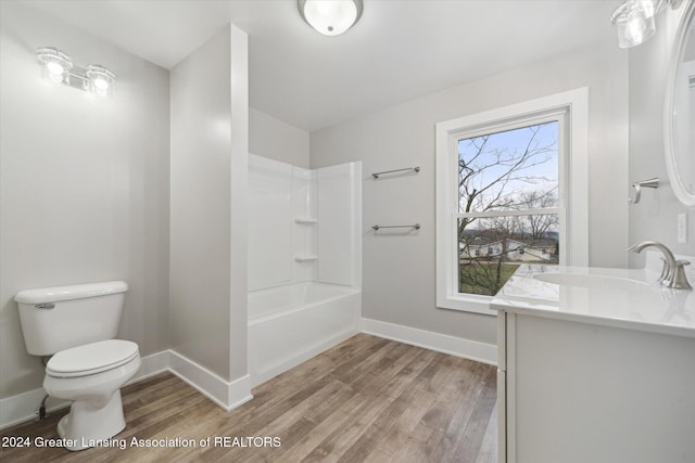 full bathroom with hardwood / wood-style floors, vanity, toilet, and tub / shower combination