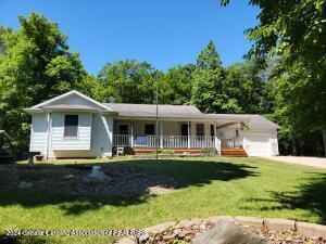 view of front of home featuring a porch, a garage, and a front lawn