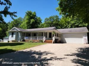 single story home with a porch, a garage, and a front lawn