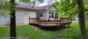 back of house featuring a deck and a lawn