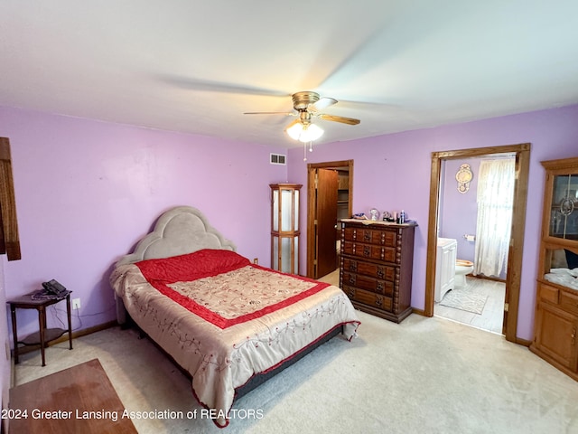 bedroom with ensuite bath, ceiling fan, and light colored carpet