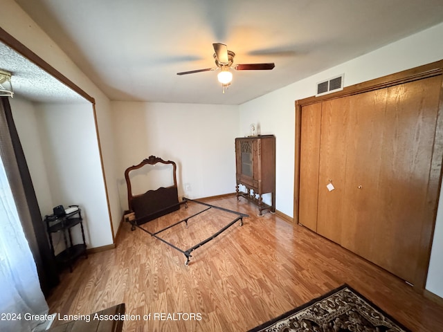 unfurnished bedroom with hardwood / wood-style flooring, a closet, and ceiling fan