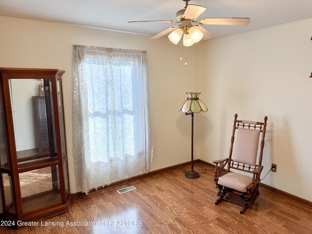 sitting room with hardwood / wood-style floors and ceiling fan