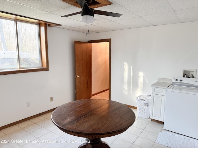 tiled dining space featuring ceiling fan, a drop ceiling, and washer / dryer