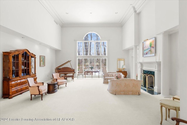 sitting room with carpet flooring, a high end fireplace, crown molding, and a towering ceiling