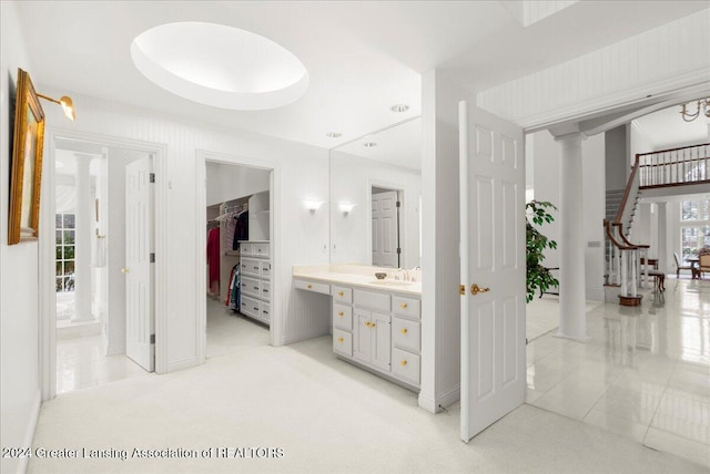 bathroom with tile patterned floors, decorative columns, and vanity