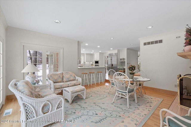 living room featuring crown molding and light hardwood / wood-style flooring