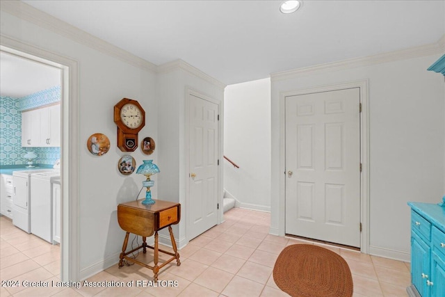 foyer with independent washer and dryer, crown molding, and light tile patterned flooring