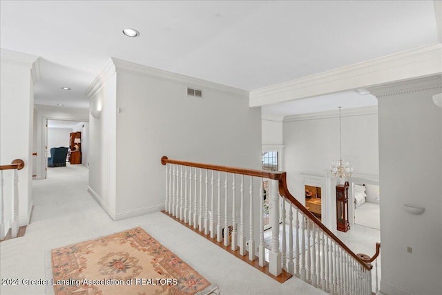 hall with crown molding, light carpet, and an inviting chandelier