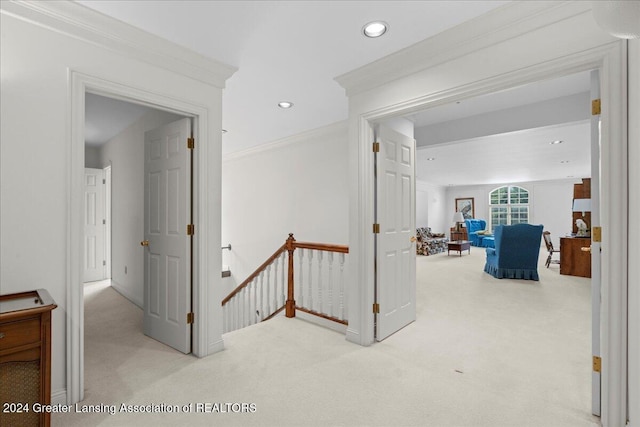 hallway featuring light colored carpet and crown molding