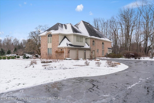 view of snow covered exterior featuring a garage